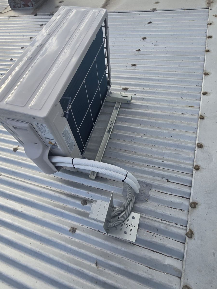 Roof-mounted outdoor unit with tidy pipework